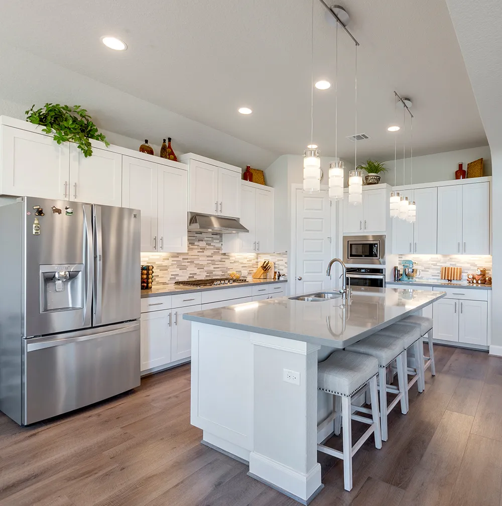 A remodeled kitchen with white cabinets and counter tops